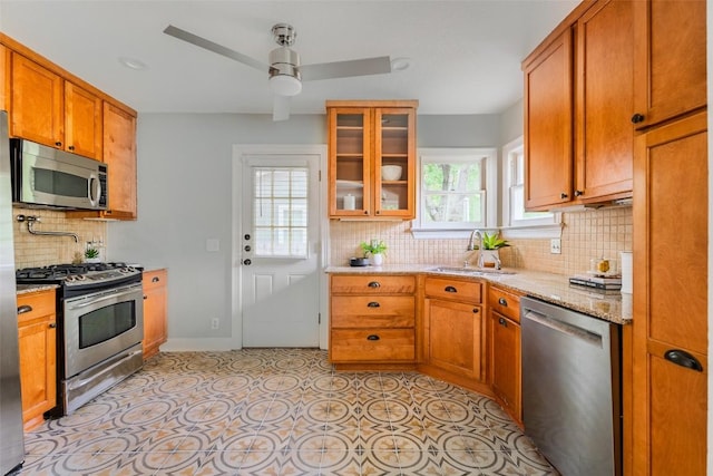 3210 Funston St, Austin, TX 78703 - kitchen with stainless steel appliances, a sink, ceiling fan, backsplash, and glass insert cabinets