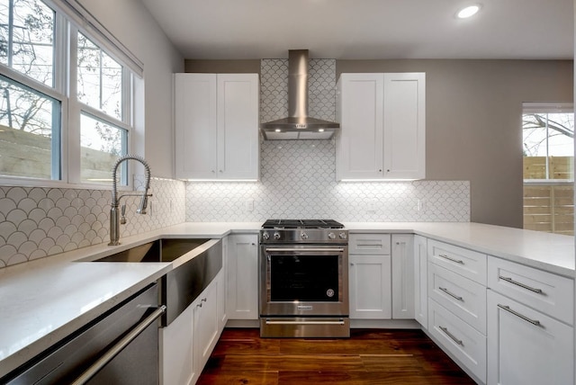 105 Elkhart St Unit 3, Austin, TX 78702 - kitchen with wall chimney exhaust hood, appliances with stainless steel finishes, light countertops, white cabinets, and recessed lighting