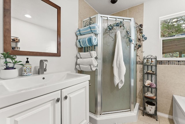1181 Live Oak Trl, Liberty Hill, TX 78642 - full bathroom with vanity, a stall shower, a garden tub, tile patterned flooring, and tile walls