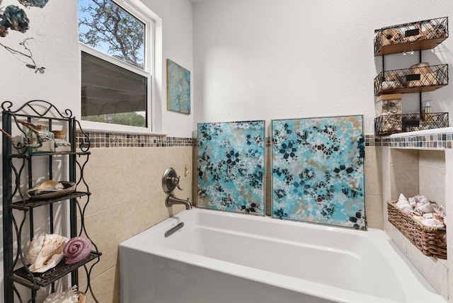 1181 Live Oak Trl, Liberty Hill, TX 78642 - bathroom featuring tile walls, a garden tub, and wainscoting