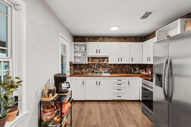 1181 Live Oak Trl, Liberty Hill, TX 78642 - kitchen featuring stainless steel appliances, open shelves, a sink, and light wood finished floors