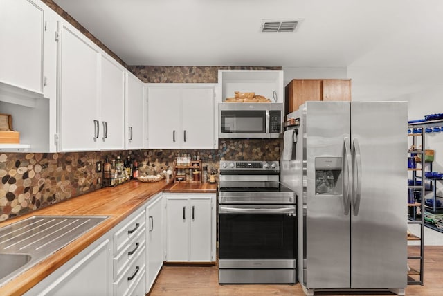 1181 Live Oak Trl, Liberty Hill, TX 78642 - kitchen with appliances with stainless steel finishes, open shelves, white cabinets, and light wood finished floors