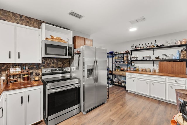 1181 Live Oak Trl, Liberty Hill, TX 78642 - kitchen with appliances with stainless steel finishes, white cabinetry, decorative backsplash, light wood-style flooring, and open shelves