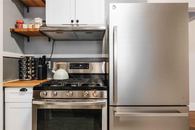 2623 Salado St, Austin, TX 78705 - kitchen featuring appliances with stainless steel finishes, under cabinet range hood, white cabinets, decorative backsplash, and wooden counters