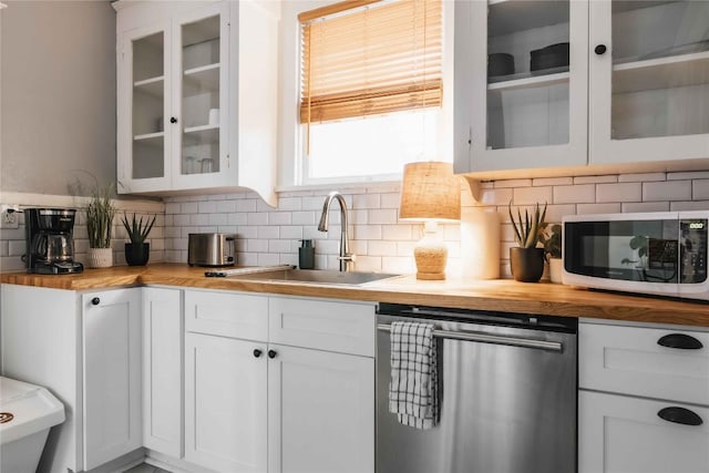 2623 Salado St, Austin, TX 78705 - kitchen featuring dishwasher, white microwave, a sink, butcher block counters, and backsplash