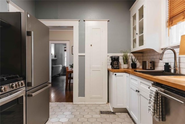 2623 Salado St, Austin, TX 78705 - kitchen featuring butcher block counters, stainless steel appliances, a sink, and white cabinetry