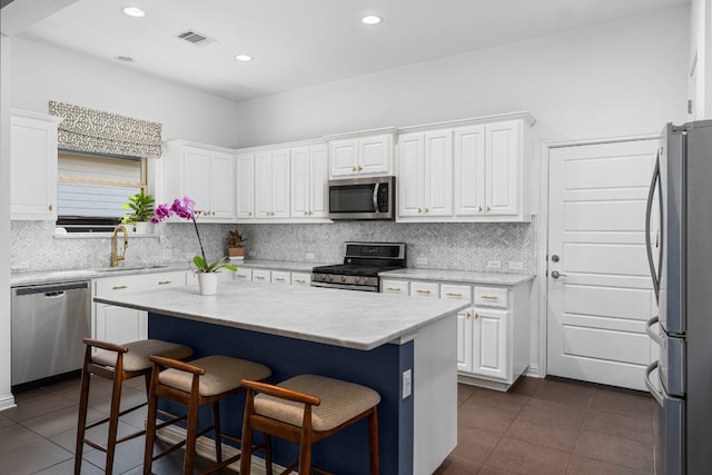 1518 Frontier Valley Dr, Austin, TX 78741 - kitchen featuring appliances with stainless steel finishes, dark tile patterned flooring, white cabinets, and recessed lighting