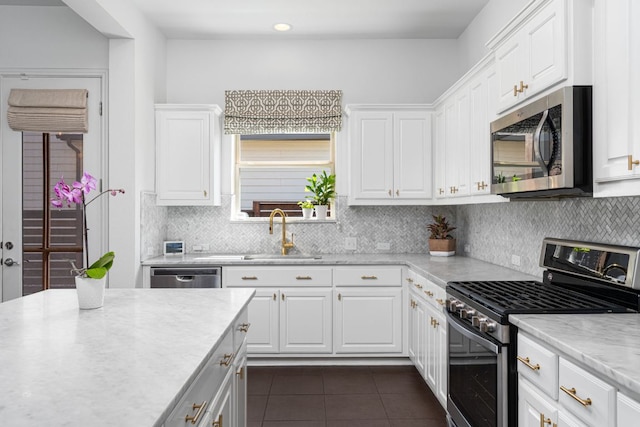 1518 Frontier Valley Dr, Austin, TX 78741 - kitchen featuring stainless steel appliances, a sink, dark tile patterned floors, tasteful backsplash, and white cabinetry