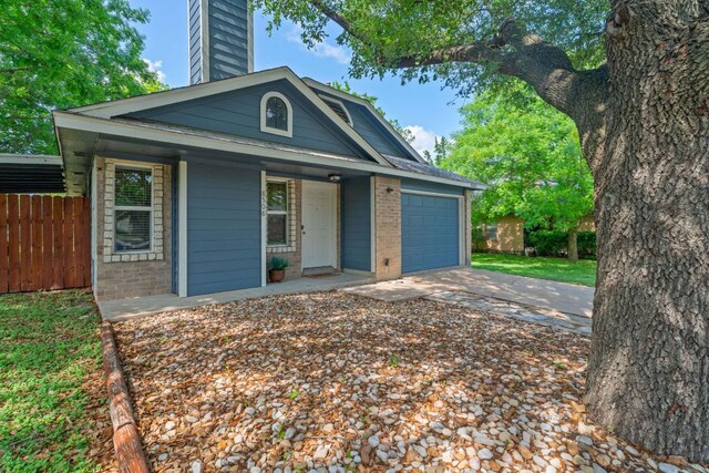 8508 Croydon Loop, Austin, TX 78748 - view of front of house featuring brick siding, a chimney, an attached garage, driveway, and a porch