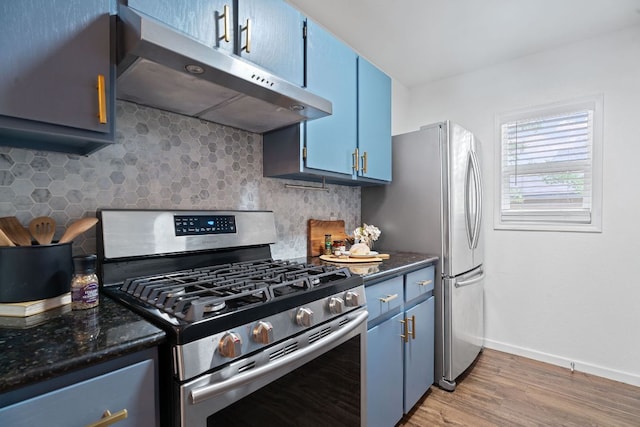 8508 Croydon Loop, Austin, TX 78748 - kitchen with under cabinet range hood, blue cabinets, stainless steel appliances, decorative backsplash, and light wood-style floors