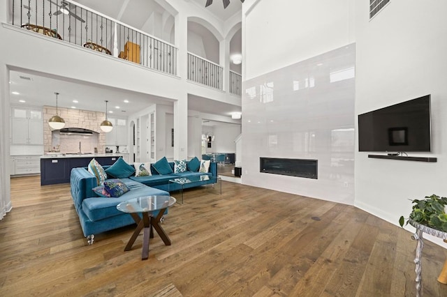 2625 Arion Cir, Austin, TX 78730 - living area featuring wood finished floors, a high ceiling, and a glass covered fireplace