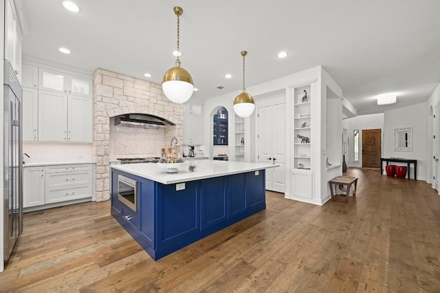 2625 Arion Cir, Austin, TX 78730 - kitchen with blue cabinetry, white cabinetry, light countertops, recessed lighting, and a center island