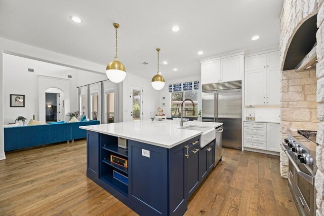 2625 Arion Cir, Austin, TX 78730 - kitchen with blue cabinets, white cabinetry, a sink, light countertops, and stainless steel appliances
