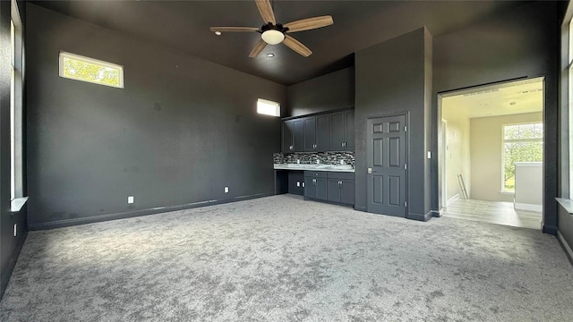 128 Gloria Blvd, Smithville, TX 78957 - unfurnished living room featuring light colored carpet, a ceiling fan, and high vaulted ceiling