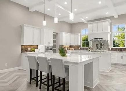 128 Gloria Blvd, Smithville, TX 78957 - kitchen with a large island, decorative backsplash, white cabinets, healthy amount of natural light, and recessed lighting
