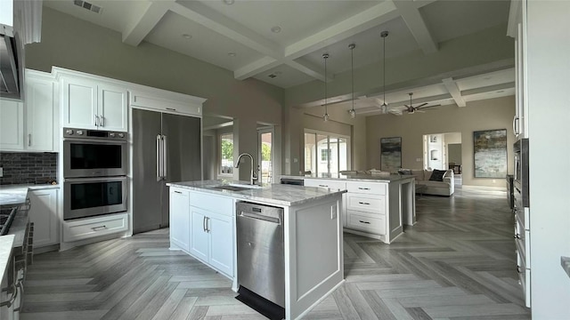 128 Gloria Blvd, Smithville, TX 78957 - kitchen featuring appliances with stainless steel finishes, coffered ceiling, a kitchen island with sink, open floor plan, and beamed ceiling