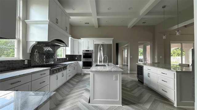 128 Gloria Blvd, Smithville, TX 78957 - kitchen featuring appliances with stainless steel finishes, beverage cooler, healthy amount of natural light, coffered ceiling, and beamed ceiling