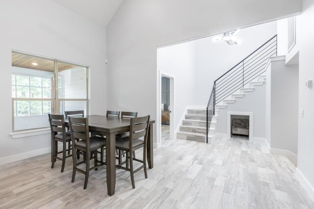 116 Mallard Rd, Bastrop, TX 78602 - dining space featuring stairway, light wood-type flooring, baseboards, and a towering ceiling