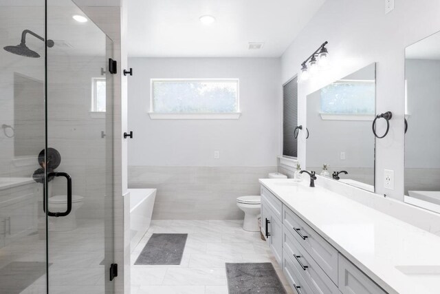 116 Mallard Rd, Bastrop, TX 78602 - full bathroom featuring double vanity, a freestanding bath, a shower stall, wainscoting, and recessed lighting