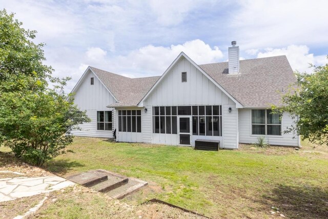 116 Mallard Rd, Bastrop, TX 78602 - rear view of house featuring a shingled roof, a sunroom, board and batten siding, and a chimney