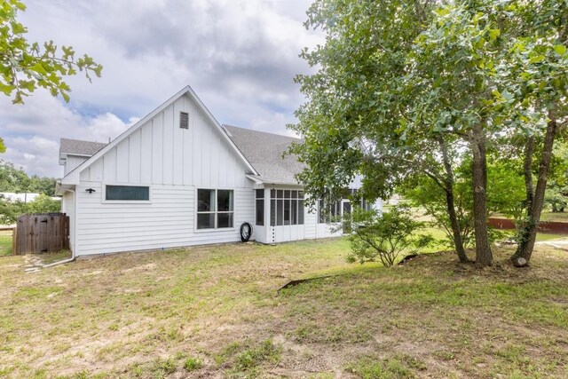 116 Mallard Rd, Bastrop, TX 78602 - back of property featuring board and batten siding, a lawn, a shingled roof, and a sunroom