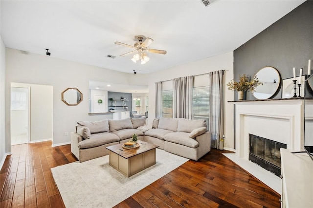 2627 Butterfly Dr, Temple, TX 76502 - living area with ceiling fan, dark wood-style floors, a fireplace with flush hearth, and baseboards