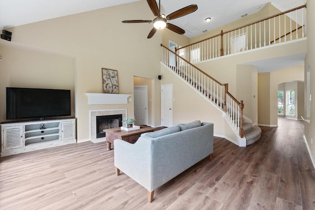 17704 Miller Falls Cv, Round Rock, TX 78681 - living area featuring high vaulted ceiling, stairs, ceiling fan, wood finished floors, and a fireplace