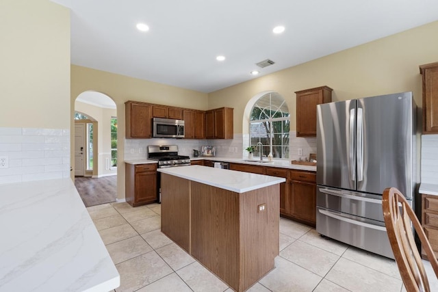 17704 Miller Falls Cv, Round Rock, TX 78681 - kitchen featuring stainless steel appliances, arched walkways, backsplash, plenty of natural light, and recessed lighting