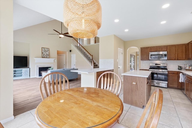 17704 Miller Falls Cv, Round Rock, TX 78681 - dining space with arched walkways, ceiling fan, light tile patterned floors, a chandelier, and a fireplace