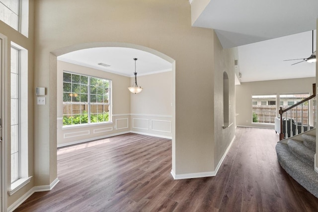 17704 Miller Falls Cv, Round Rock, TX 78681 - foyer entrance with arched walkways, crown molding, stairs, dark wood-style floors, and a towering ceiling