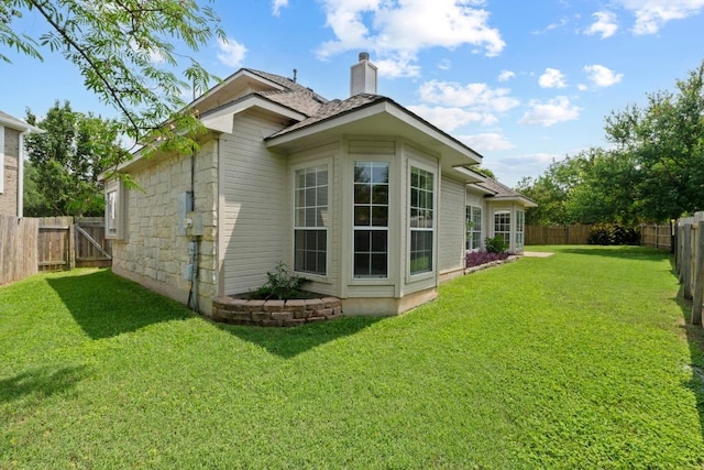 17704 Miller Falls Cv, Round Rock, TX 78681 - back of house featuring a chimney, a fenced backyard, and stone siding