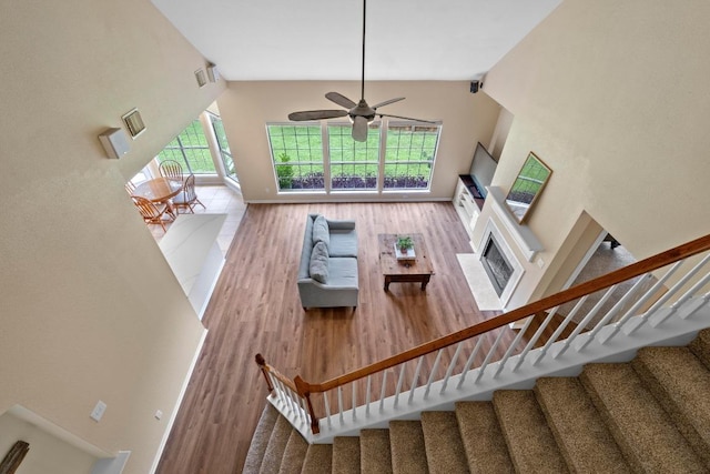 17704 Miller Falls Cv, Round Rock, TX 78681 - living room with wood finished floors, stairway, ceiling fan, high vaulted ceiling, and a fireplace with flush hearth