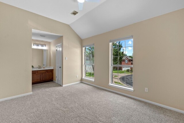 17704 Miller Falls Cv, Round Rock, TX 78681 - unfurnished bedroom with light carpet, lofted ceiling, ensuite bath, and a ceiling fan