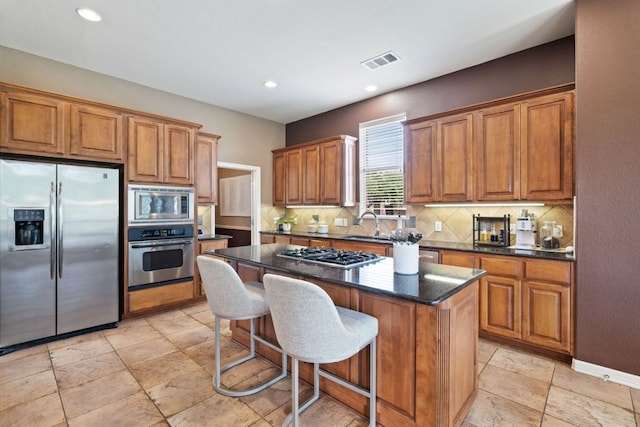 1613 Westend Pl, Round Rock, TX 78681 - kitchen with stainless steel appliances, brown cabinets, backsplash, and recessed lighting