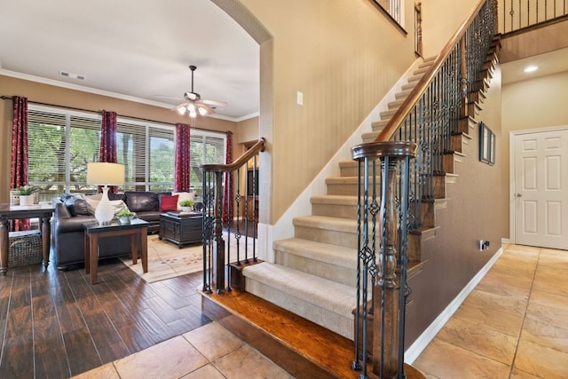 1613 Westend Pl, Round Rock, TX 78681 - staircase featuring a ceiling fan, ornamental molding, tile patterned flooring, and arched walkways