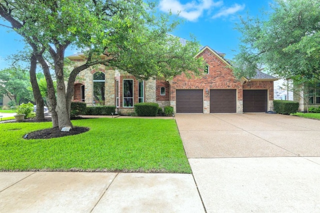 1613 Westend Pl, Round Rock, TX 78681 - view of front of property with a garage, a front lawn, concrete driveway, stone siding, and brick siding