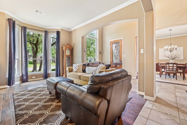 1613 Westend Pl, Round Rock, TX 78681 - living room featuring arched walkways, a chandelier, ornamental molding, and wood finished floors