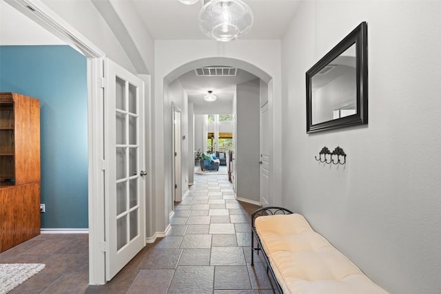 2705 Rosemount Cv, Round Rock, TX 78665 - hallway featuring arched walkways, baseboards, and stone tile flooring