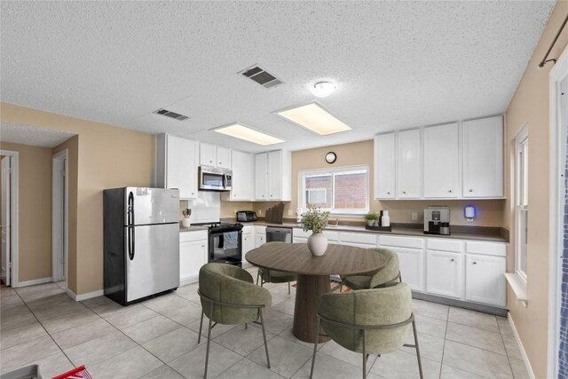 2507 Byfield Dr, Cedar Park, TX 78613 - kitchen with stainless steel appliances, a textured ceiling, white cabinets, and light tile patterned floors