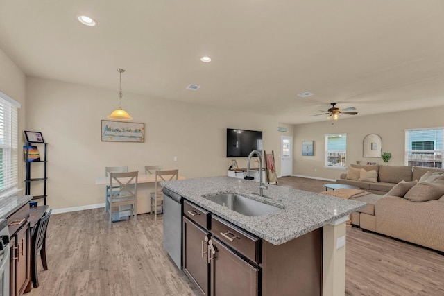 409 Red Matador Ln, Leander, TX 78641 - kitchen with a sink, stainless steel dishwasher, light wood-style flooring, baseboards, and recessed lighting