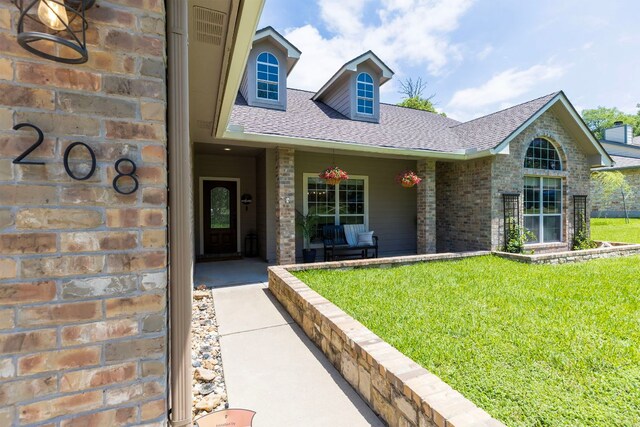 208 E Nakoma, Round Rock, TX 78664 - view of front facade with a shingled roof, a front yard, brick siding, and covered porch