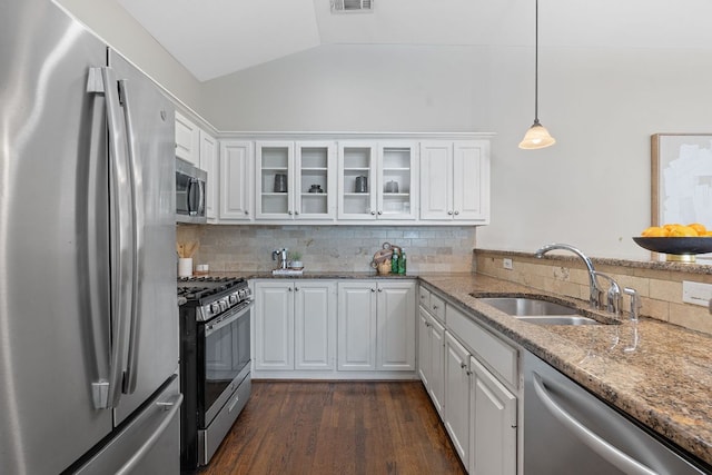 6706 Fort Davis Cv Unit B, Austin, TX 78731 - kitchen featuring appliances with stainless steel finishes, vaulted ceiling, decorative backsplash, glass insert cabinets, and white cabinets