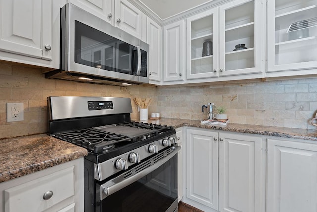 6706 Fort Davis Cv Unit B, Austin, TX 78731 - kitchen with stainless steel appliances, white cabinetry, glass insert cabinets, backsplash, and dark stone countertops