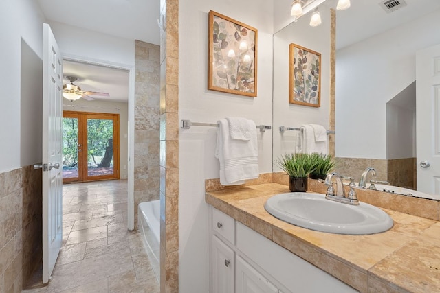 6706 Fort Davis Cv Unit B, Austin, TX 78731 - bathroom with stone tile flooring, vanity, french doors, a ceiling fan, and bathtub / shower combination