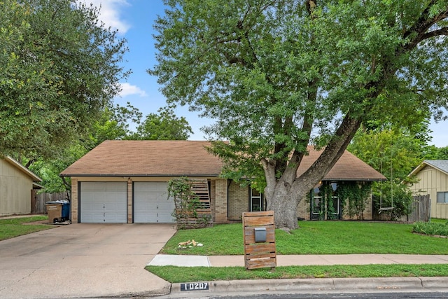 10207 Ray Ave, Austin, TX 78758 - view of front of home featuring a front yard, concrete driveway, a garage, and brick siding