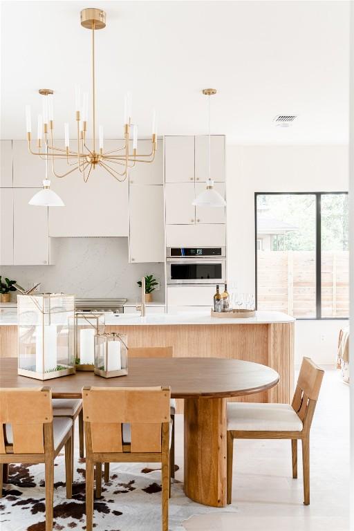 2301 Canterbury, Austin, TX 78702 - kitchen featuring oven, white cabinets, a chandelier, and hanging light fixtures