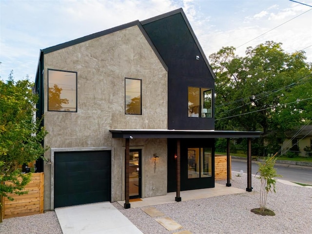 2301 Canterbury, Austin, TX 78702 - modern home featuring an attached garage, stucco siding, a porch, and driveway