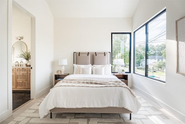 2301 Canterbury, Austin, TX 78702 - bedroom with lofted ceiling, a sink, baseboards, and ensuite bath