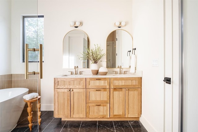2301 Canterbury, Austin, TX 78702 - bathroom featuring a freestanding bath, double vanity, baseboards, and marble finish floors