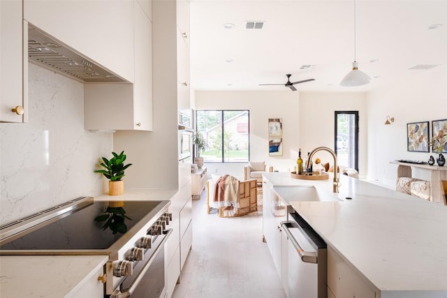 2301 Canterbury, Austin, TX 78702 - kitchen with stainless steel appliances, wall chimney range hood, a sink, light wood-style flooring, and open floor plan
